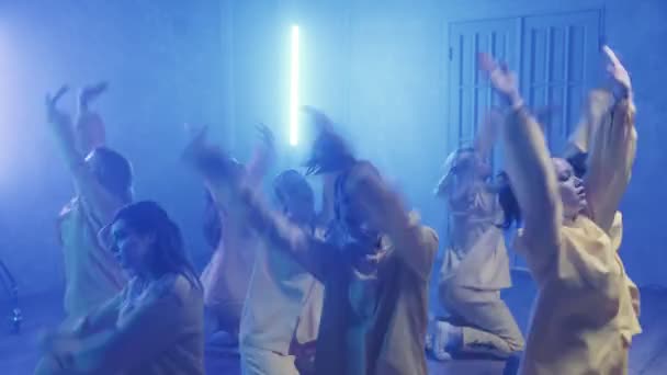 A group of beautiful girls dancing in a room with blue lighting in yellow suits. Dances — Stock Video