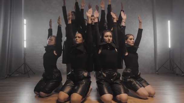 A group of beautiful girls dancing indoors in black suits. Dances — Stock video