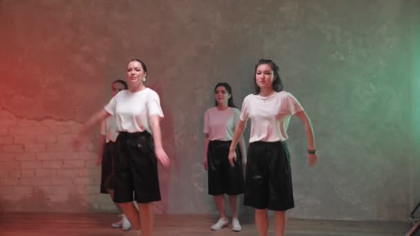 A group of beautiful girls dancing in a room with red and green lighting and. Dances — Vídeo de Stock