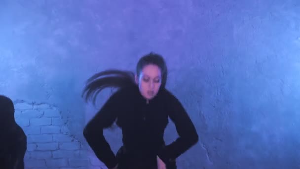 A group of beautiful girls dancing in a room with blue lighting in black suits. Dances — Video Stock