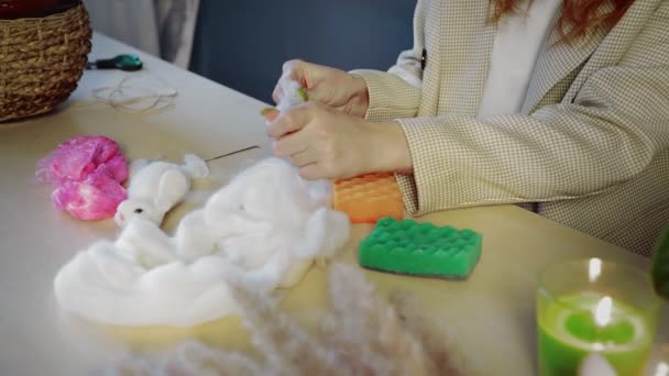 Nahaufnahme eines schönen rothaarigen Mädchens, das Wolle rollt und Spielzeug herstellt. Handarbeit — Stockvideo