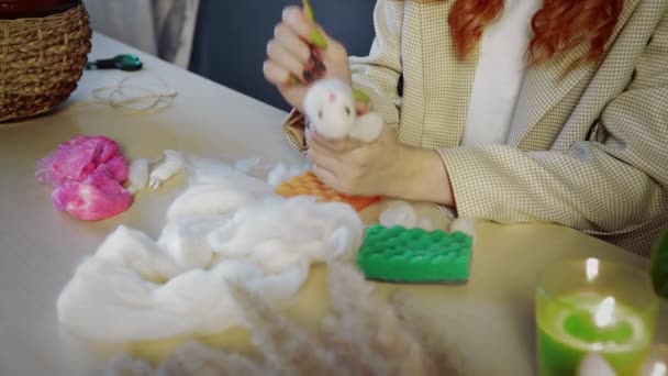 Close-up de uma linda menina ruiva, ela rola lã e cria brinquedos. Trabalho artesanal — Vídeo de Stock