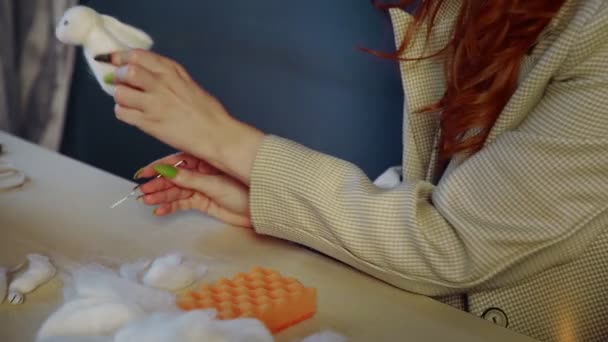 Közelkép egy gyönyörű vörös hajú lányról, aki gyapjút sodor és játékokat készít. Kézzel készített munka — Stock videók