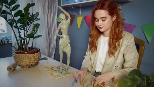 Krásná rusovlasá dívka vytesává plastikovou sochu. Ruční práce — Stock video