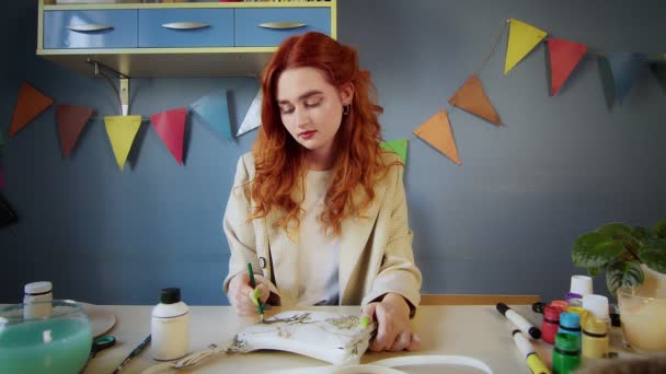 가방에 다양 한 색상의 페인트를 칠 한 아름다운 빨간 머리 소녀의 일반적 인 계획. 손으로 만든 일 — 비디오