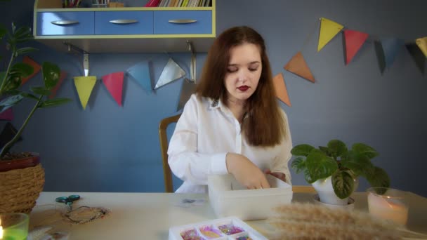 Ein schönes Mädchen im weißen Hemd schafft eine Perlendekoration. Handarbeit — Stockvideo