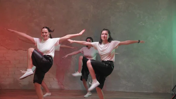 Un grupo de hermosas chicas bailando en una habitación con iluminación roja y verde y. Bailes — Foto de Stock