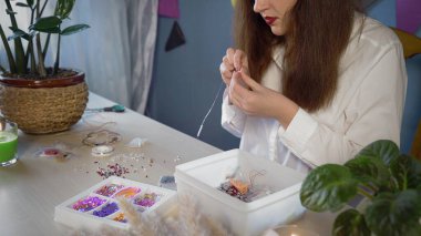 Beyaz gömlekli güzel bir kızın yakın çekimi boncuk süsleme oluşturur. El yapımı iş