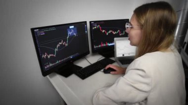 Kız bilgisayarda oturuyor ve Online Borsa Çizelgesine bakıyor Bearish ve Bullish Trends of Bitcoin Para Birimi 'ni gösteriyor. Gerçek zamanlı olarak.