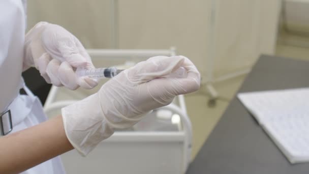 Enjeksiyon aşısı için aşı hazırlayan kadın bir doktorun ellerini yakın plan çekin. — Stok video