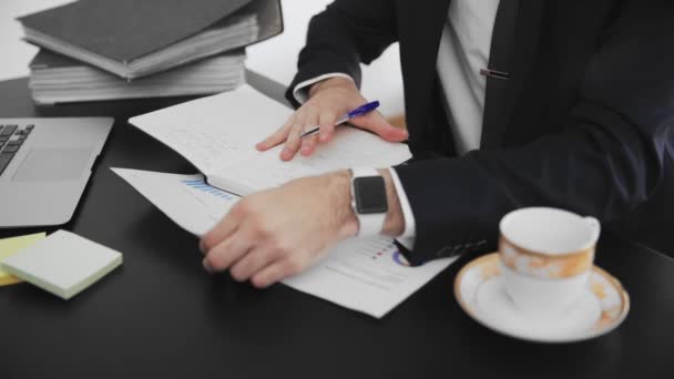 Közelkép férfi kézről, amint információt ír egy magazinban. Egy üzletember, aki egy irodában dolgozik, kézzel jegyzetel.. — Stock videók