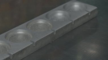 Karamel yuvarlak şekillere dökülüyor. Çubukta lolipop yapmak