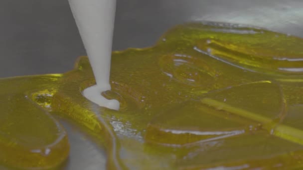 Um close-up de um chef de pastelaria se baseia em pirulitos. Fazendo pirulitos em um pau — Vídeo de Stock