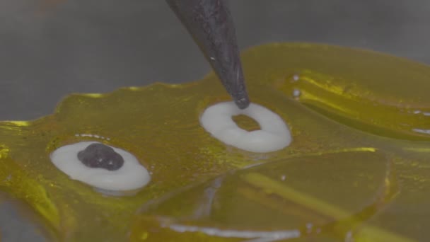 Um close-up de um chef de pastelaria se baseia em pirulitos. Fazendo pirulitos em um pau — Vídeo de Stock