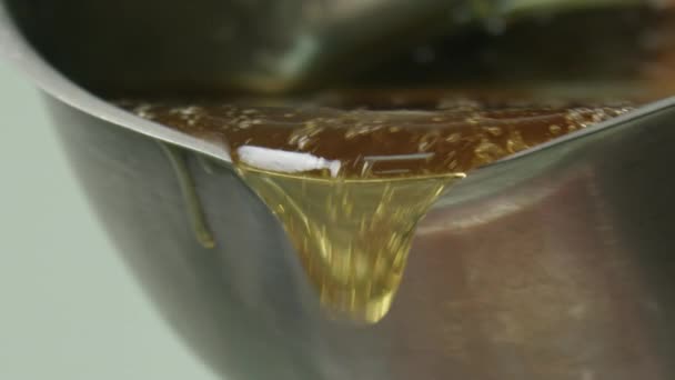 Close-up do molho derretido de caramelo fervente que sai da concha. Fazendo pirulitos em um pau — Vídeo de Stock