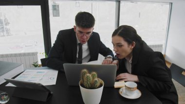 Bir iş adamı ve bir kadın masada oturup iş meselelerini çözüyor ve yeni fikirlerin tadını çıkarıyorlar. İş adamları