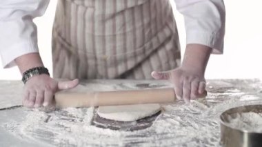 Pasta şefi masada haddeleme pin ile hamur haddeleme. Ellerinizi kapatın. ön görünüm