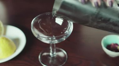 Bir kadın eli kadehten bardağa su doldurur.