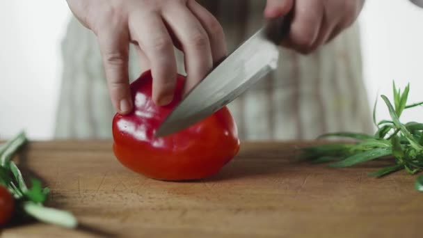 Male hands cut pepper on a wooden board with a knife — Stock Video