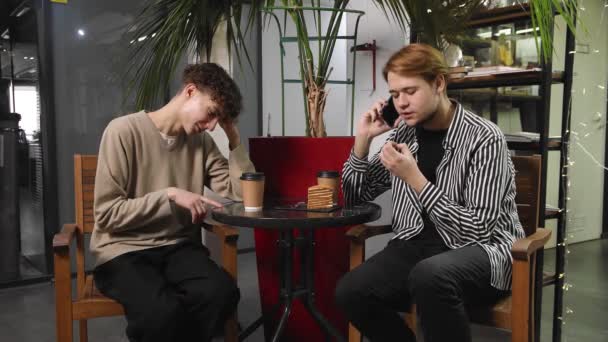 Deux gays à un rendez-vous sont assis dans un café. Le gars parle au téléphone, et l'autre est offensé par lui. LGBT — Video