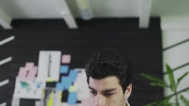 Kafkas görünümlü genç bir adam grafik tablet üzerine resim çizer. Uzaktan kumanda. Serbest çalışıyorum. Video hareket halinde. Yakın plan.