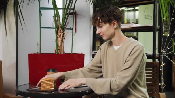 Detailní záběr chlapa sedícího v kavárně a zapisujícího si do sešitu. Číšnice mu donese objednávku. Kavárna — Stock video
