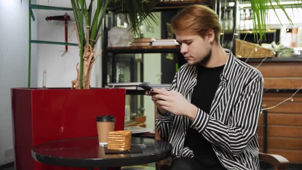 Κοντινό πλάνο ενός τύπου που κάθεται σε ένα καφέ και φωτογραφίζει τη σύνθεση στο τραπέζι με το κινητό του. Καφετέρια — Αρχείο Βίντεο