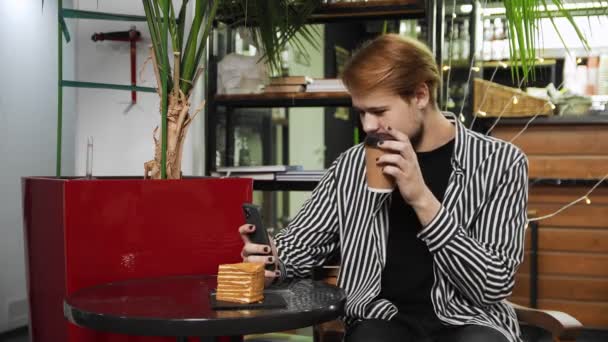 Κοντινό πλάνο ενός τύπου που κάθεται σε ένα καφέ και μιλάει με βίντεο στο τηλέφωνο. Καφετέρια — Αρχείο Βίντεο