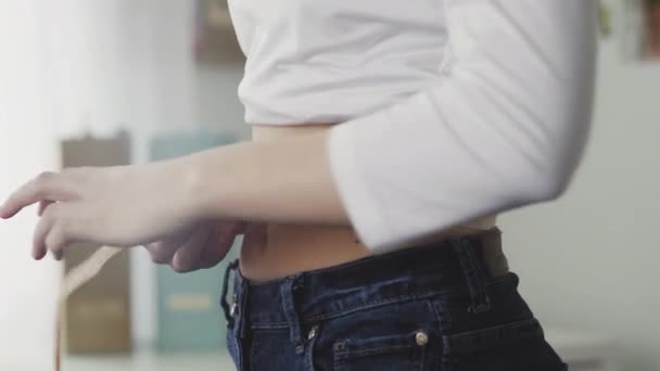 鏡の前に立つ若い女性は、腰の周囲をテープで測定する。閉鎖 — ストック動画