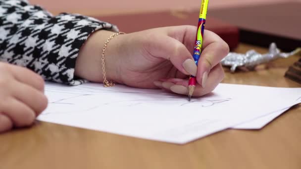 En penna i en kvinnas händer. Ritning på pappersark med en enkel penna. Begreppet kreativitet och teckning. — Stockvideo