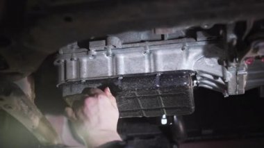 Araba motorundaki yağı bir oto tamircisi değiştirir..