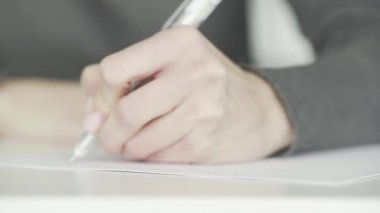 Tanınmayan bir iş kadını, iş görüşlerini ve planlarını bir deftere yazar ve bir yapılacaklar listesi hazırlar.