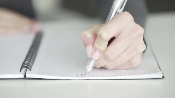 En oigenkännlig affärskvinna skriver ner affärsidéer och planer i en anteckningsbok för att göra en att göra-lista, närbild — Stockvideo