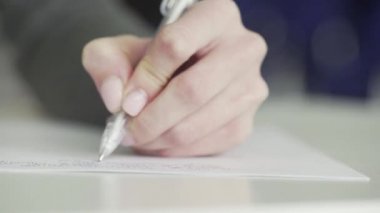 Tanınmayan bir iş kadını, iş görüşlerini ve planlarını bir deftere yazar ve bir yapılacaklar listesi hazırlar.