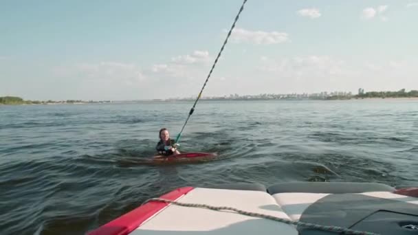 A lány egy szörfös, aki wakeboardozik. Egy tapasztalt wakeboardos segít egy lánynak. — Stock videók