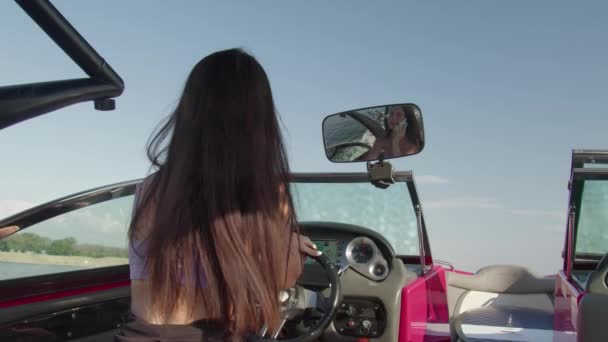 Une femme conduit un bateau à moteur et s'assoit au téléphone par une chaude journée d'été — Video