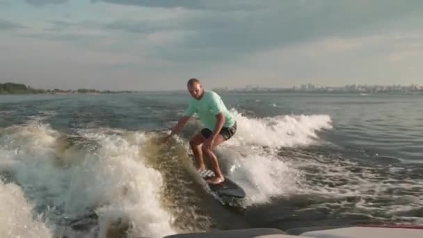 Surfer skaczący na desce. Doświadczony wakeboarder spryskuje kamerą krople wody. — Wideo stockowe