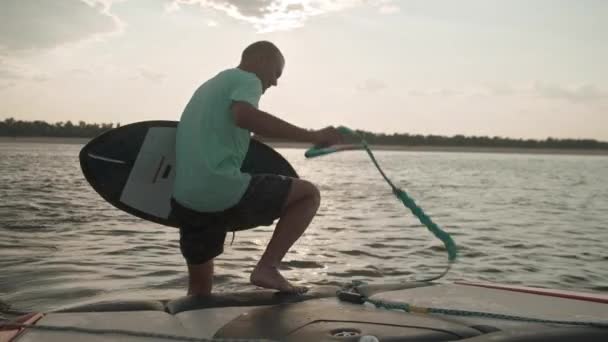 一个人带着滑板坐在汽艇上 — 图库视频影像