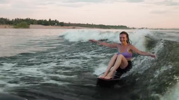 Una surfista saltando sobre un wakeboard. Un wakeboarder experimentado salpica el agua cae en la cámara. — Vídeo de stock