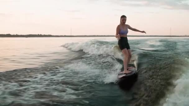 Une surfeuse sautant sur un wakeboard. Un wakeboarder expérimenté éclabousse des gouttes d'eau dans la caméra. — Video