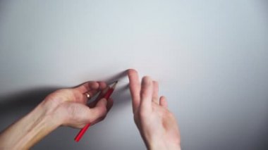 Tanınmayan bir adamın, tavan lambası yerleştirmek için üssü delmesi. Onarım