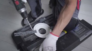 Bir adam metal bir yüzeyi matkapla deliyor, yakın plan..