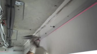 Bir evde ya da dairede tamirat yapan tanınmayan bir adamın ellerine yakın çekim. Gergin tavan