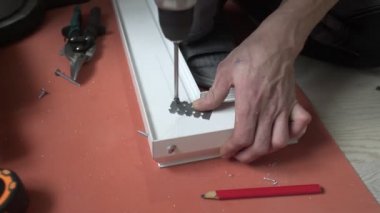 Bir adam metal bir yüzeyi matkapla deliyor, yakın plan..