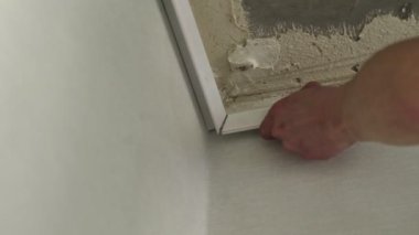 Yakın plan, bir adam esnek tavanlar için çerçeve kuruyor. Bir apartman dairesinde ya da bir evde onarım