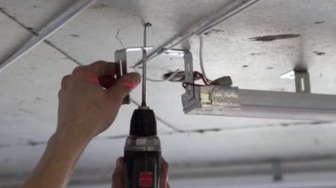 Bir evde ya da dairede tamirat yapan tanınmayan bir adamın ellerine yakın çekim. Gergin tavan