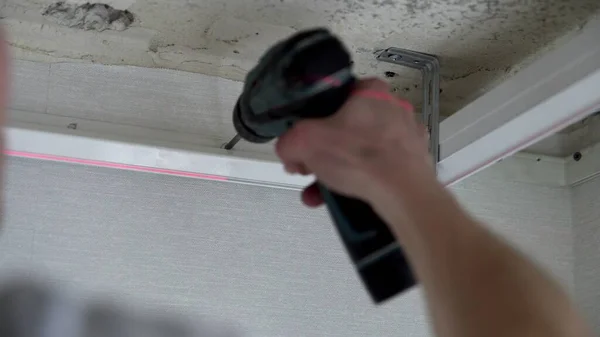 Bir evde ya da dairede tamirat yapan tanınmayan bir adamın ellerine yakın çekim. Gergin tavan