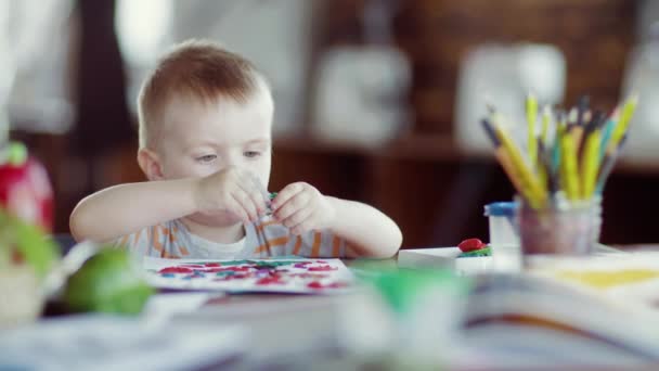 Un niño juega con plastilina colorida en la mesa — Vídeo de stock