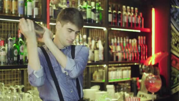 Een jonge barman bereidt een cocktail in de bar. — Stockvideo