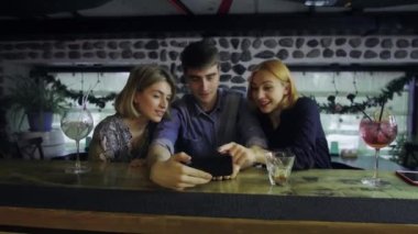 Barda bir adam ve iki kız iletişim kuruyor, gülümsüyor..